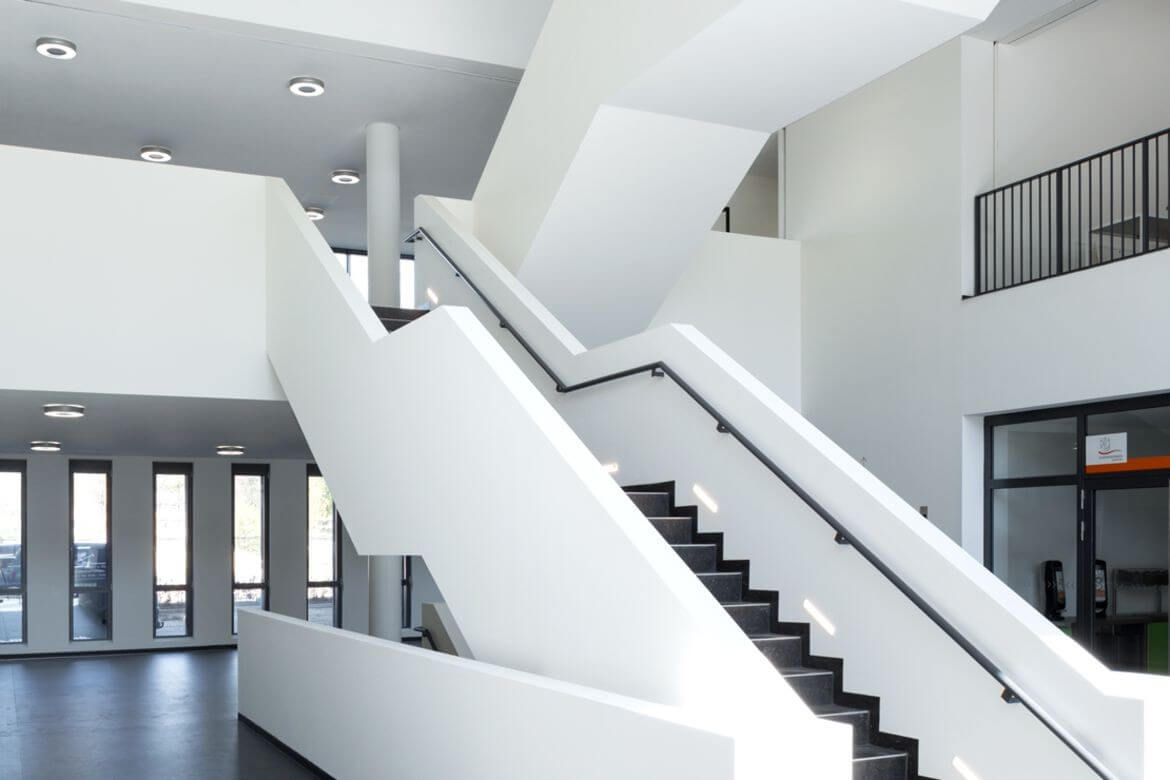 Ein weißes Treppenhaus mit dunklen Stufen